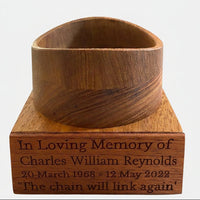Wooden stand for football urn with engraved text on a white background