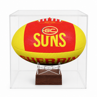 A red and yellow GS'Suns' football displayed inside a clear acrylic display case on a small wooden stand.