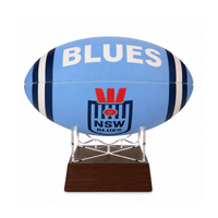 A light blue NSW Blues rugby ball mounted on a clear acrylic stand with a dark brown wooden base, shown against a plain white background.