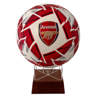 Red and white soccer ball with Arsenal logo on a wooden stand