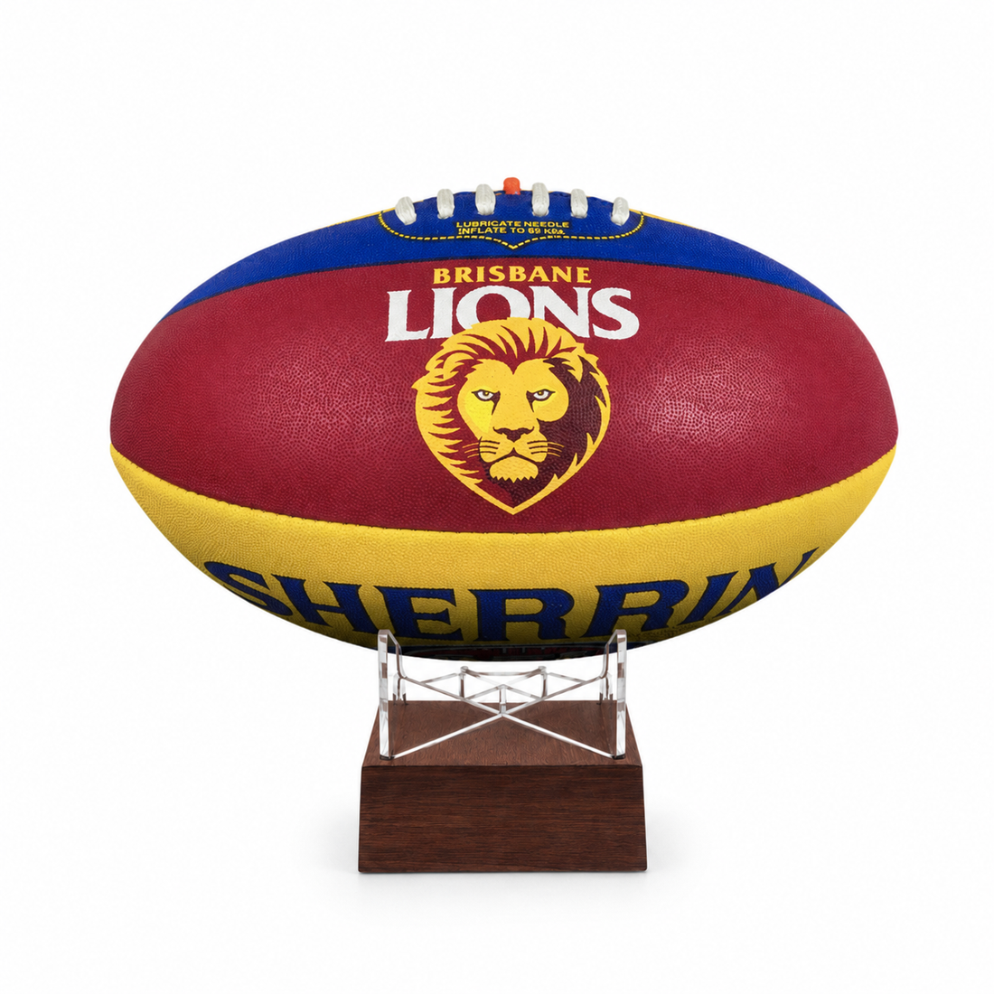 A Brisbane Lions AFL ball displayed on a clear stand with a dark wood base, set against a plain white background.
