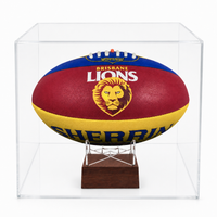 A Brisbane Lions AFL ball displayed inside a clear acrylic display case on a small wooden stand, photographed against a clean white background.