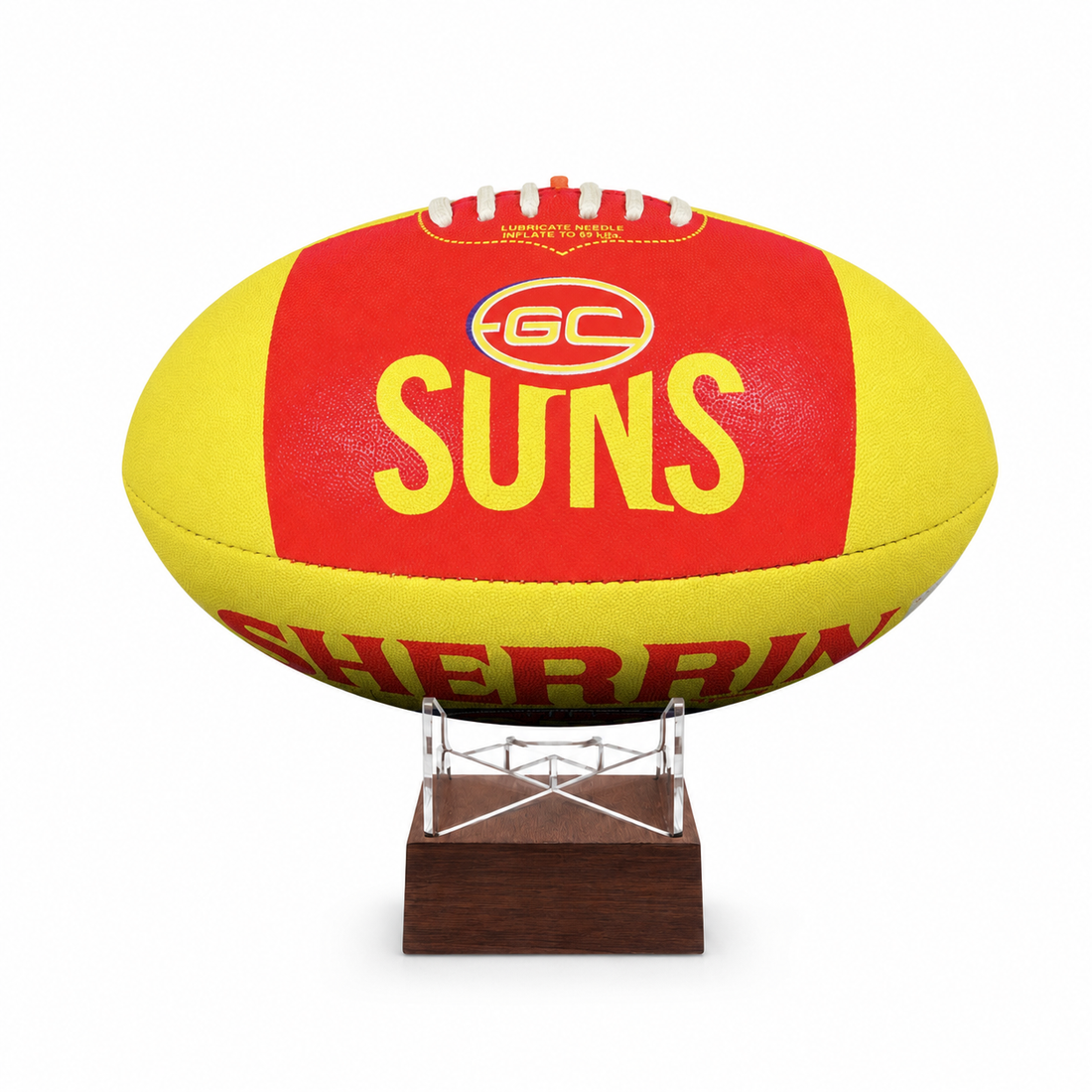 A yellow and red GC Suns football displayed on a clear stand with a dark brown wooden base against a white background.