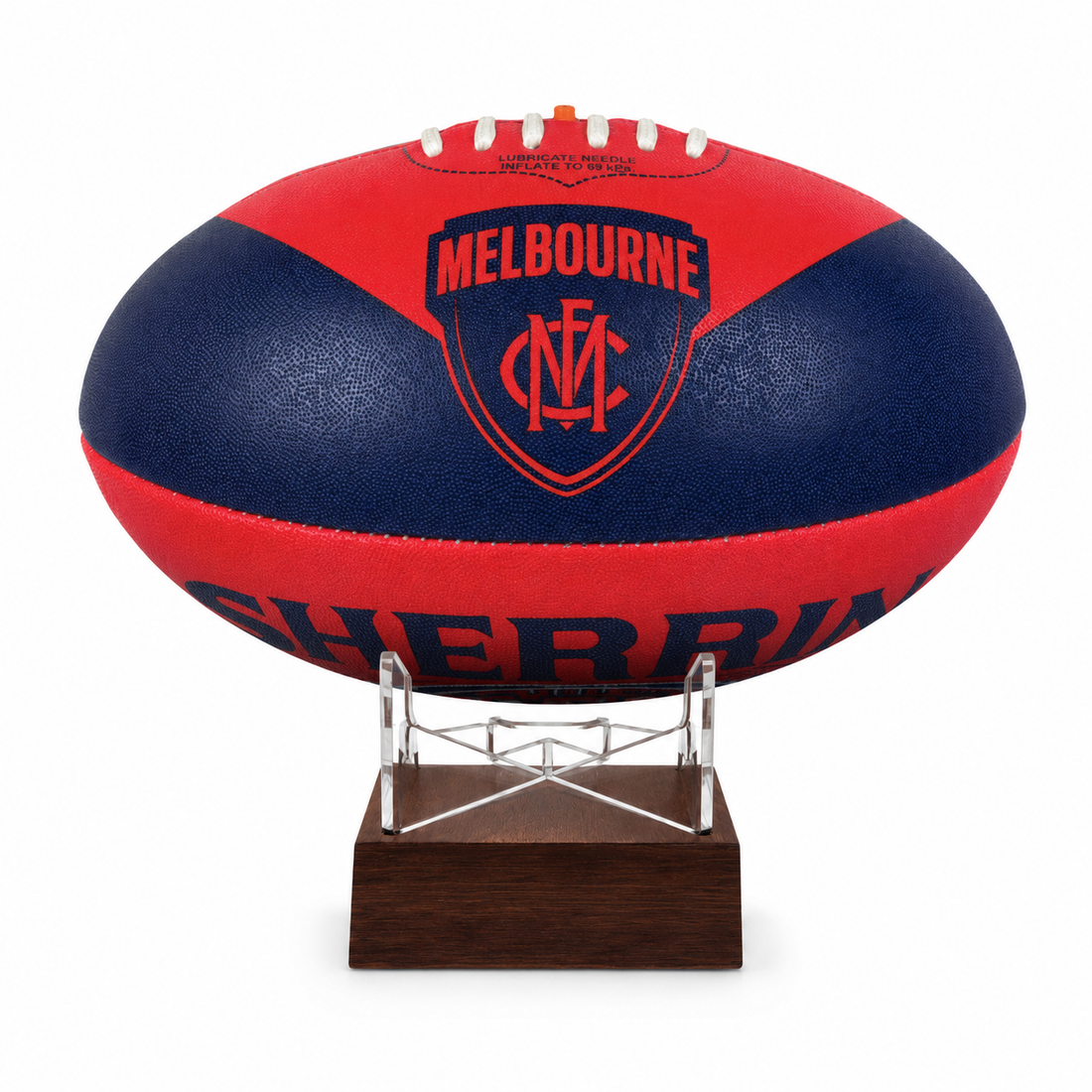 A red and navy blue Melbourne Football Club AFL ball urn displayed on a clear acrylic stand with a dark wood base against a white background.
