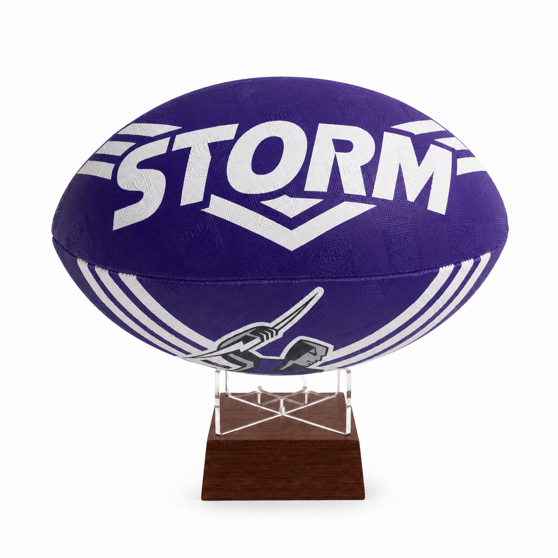 A purple Storm rugby ball with white lettering and graphics, displayed on a clear acrylic stand with a dark brown wooden base against a white background.