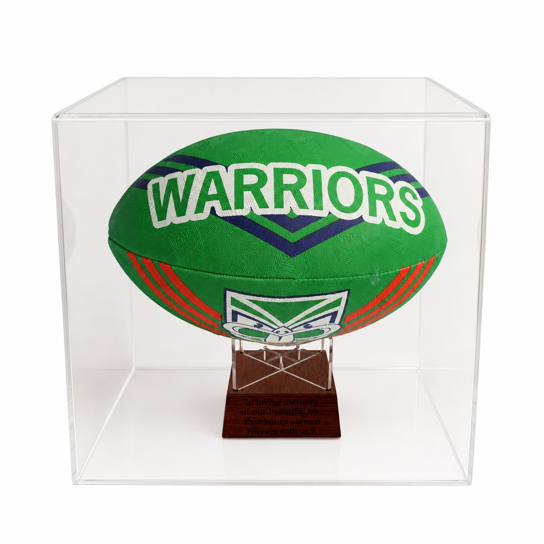 A green and navy blue Warriors rugby ball mounted on a clear acrylic display case with a small wooden base.