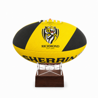 A yellow and black Richmond Tigers rugby ball displayed on a clear acrylic stand with a dark brown wooden base against a white background.