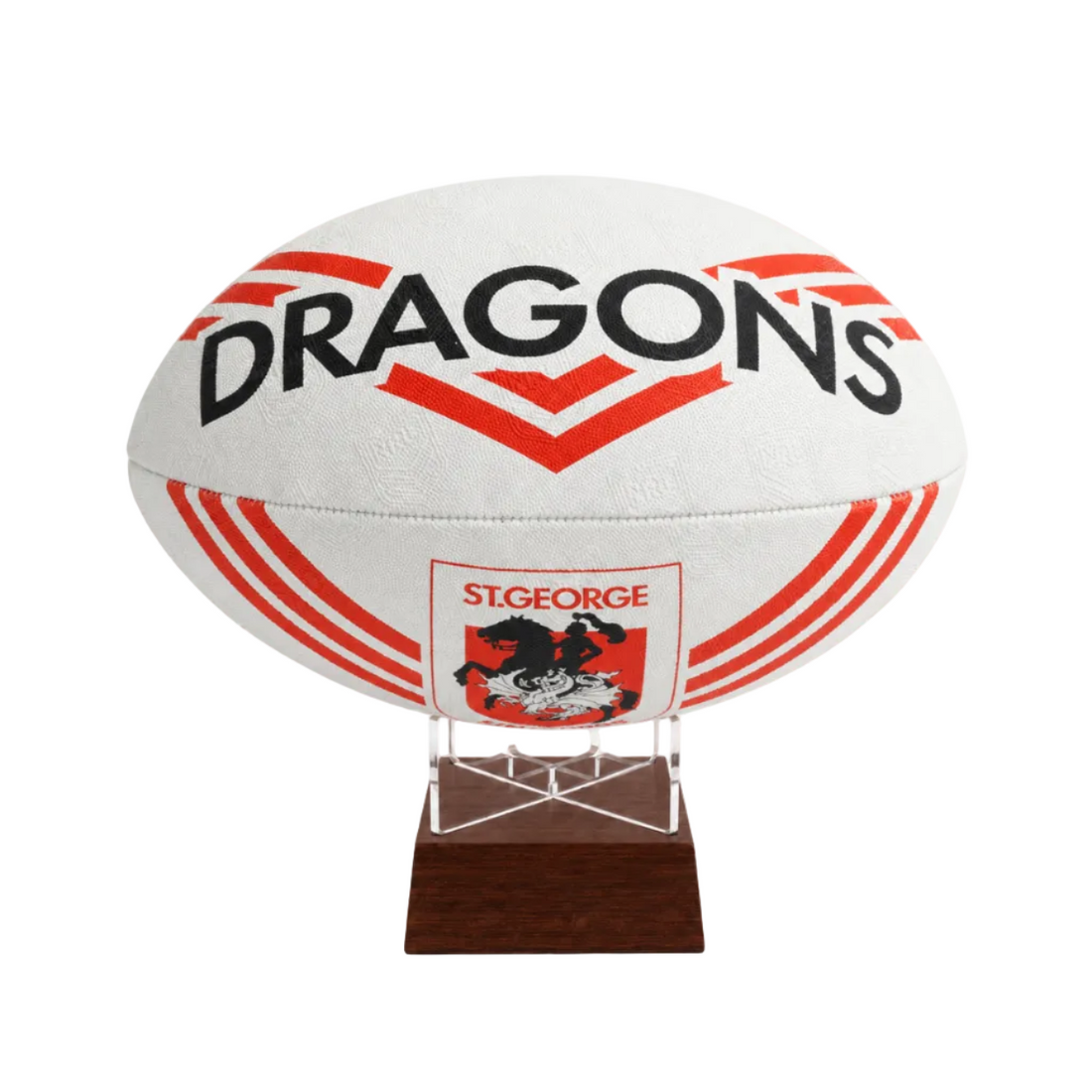 A white St. George Dragons rugby ball displayed on a clear acrylic stand with a dark brown wooden base against a plain white background.