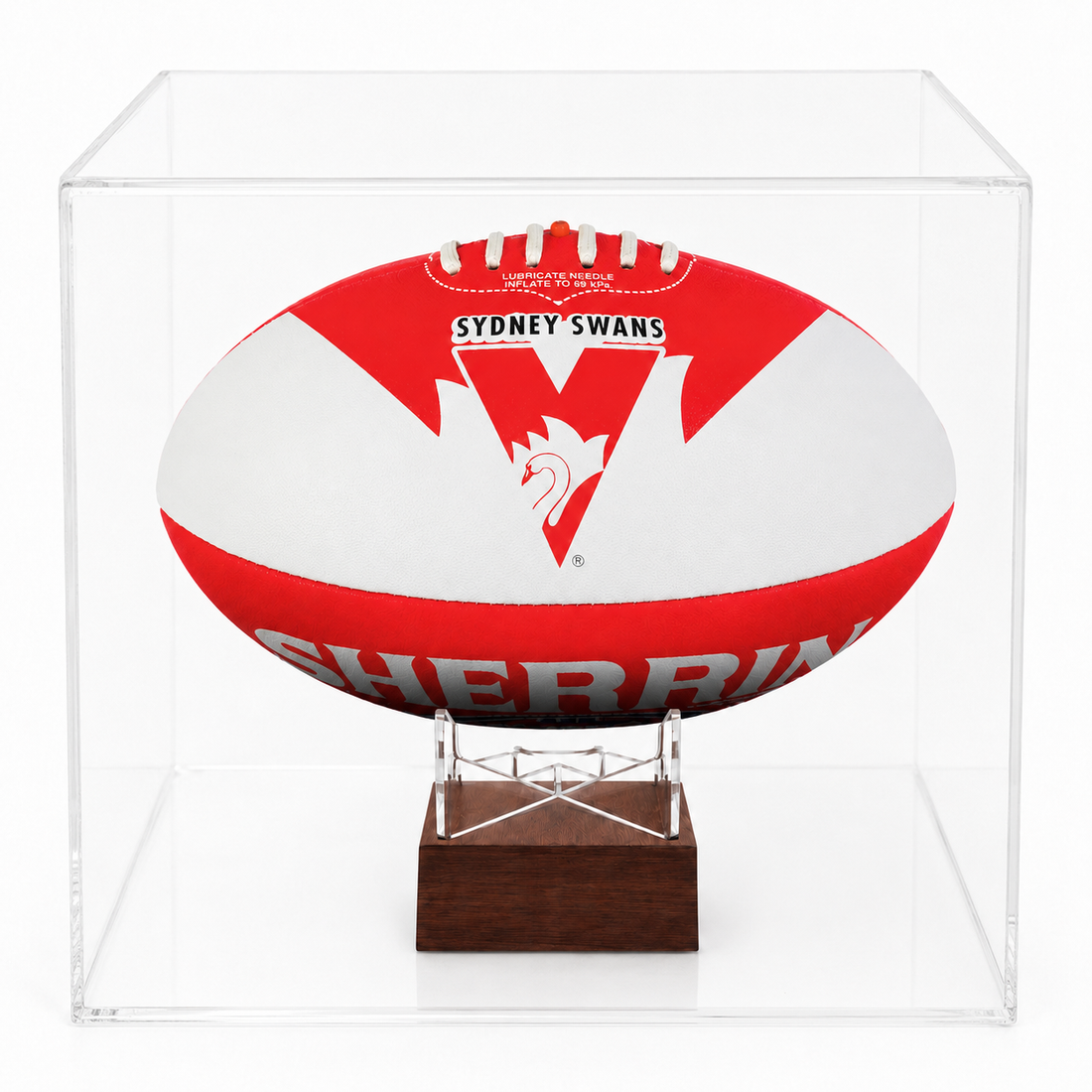 A cremation urn designed to look like a Sydney Swans AFL football with red and white stripes, featuring the Sydney Swans logo and the year 1914 on the upper part inside a clear acrylic display case on a dark wood stand, photographed against a clean white background.