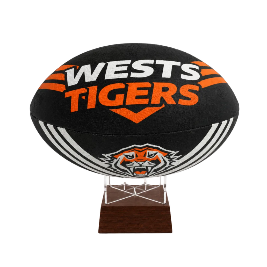 A black Wests Tigers rugby ball displayed on a clear acrylic stand with a dark brown wooden base, set against a plain white background.